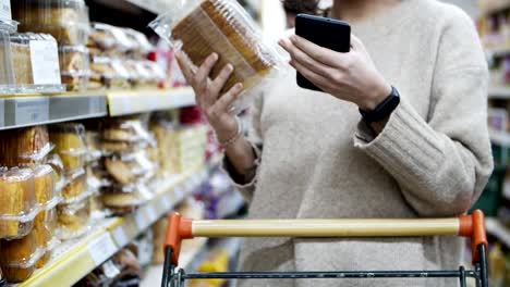 Frau-hält-Smartphone-und-wählt-Waren