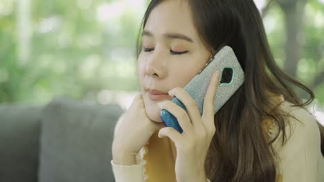 Close-up-shot-of-4K-footage-of-young-asian-woman-using-mobile-at-home.