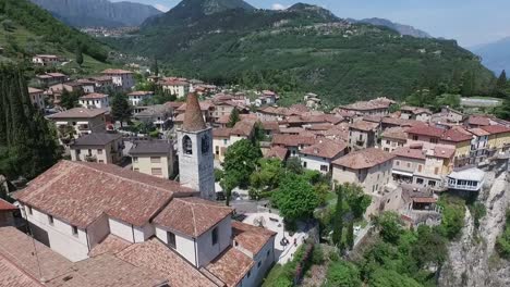 Italien.-Kirche-auf-dem-Berg-und-der-Altstadt-entfernt.-Panorama-des-wunderschönen-Gardasees-umgeben-von-Bergen.-Videodreh-mit-Drohne