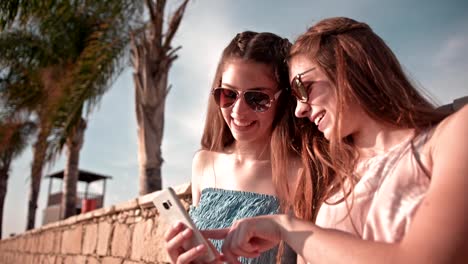 Junge-Hipster-Frauen-Spaß-lesen-SMS-am-Strand