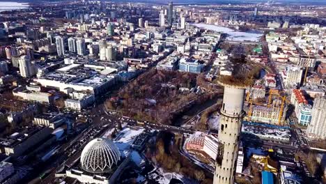 Aerial-view-on-abandoned-TV-tower-in-Yekaterinburg.-Clip.-Aerial-view-of-abandoned,-old-building,-TV-tover-or-communication-tower-with-city-landscape-background