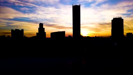 Aerial-view-on-beautiful-colorful-dramatic-sunset-sky-over-silhouette-of-the-city.-Clip.-City-silhouettes-at-sunset-with-skyscrapers-background.-Sunset-in-town-with-business-centres-background