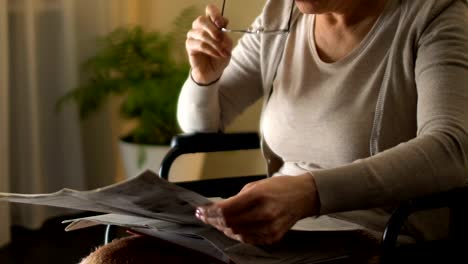 Mujer-con-discapacidad-tratando-de-leer-el-periódico-a-través-de-las-lentes,-mala-vista