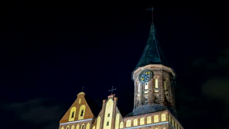 Illumination-on-a-historic-building.-Historic-Landmark.-Time-lapse.-Cathedral-of-Kant-in-Kaliningrad.-Old-medieval-castle-at-night-against-the-sky.-An-ancient-tower-with-a-clock.-Timelapse.