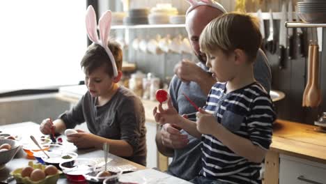 Padre-a-hijos-de-huevos-de-Pascua-de-color