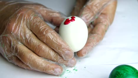 Applying-a-red-paint-on-an-egg