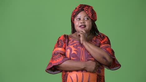 Overweight-beautiful-African-woman-wearing-traditional-clothing-against-green-background