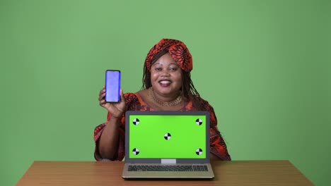 Overweight-beautiful-African-woman-wearing-traditional-clothing-against-green-background