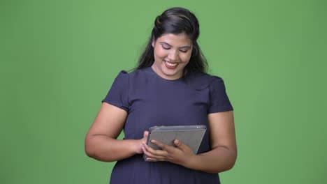 Young-overweight-beautiful-Indian-businesswoman-against-green-background