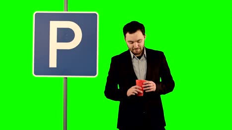 Mann-mit-Tasse-Tee-in-der-Nähe-von-Parkplatz-Schild-auf-einem-grünen-Bildschirm