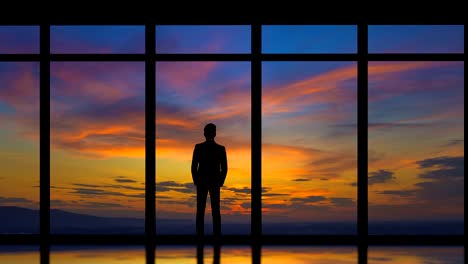 The-man-standing-near-windows-on-the-sunrise-background.-time-lapse