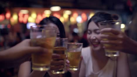 Viajero-mochilero-mujeres-asiáticas-lesbianas-lgbt-par-de-viajes-en-Bangkok,-Tailandia.-Consumo-de-alcohol-o-cerveza-con-los-amigos-y-tener-parte-en-el-camino-de-Khao-San.