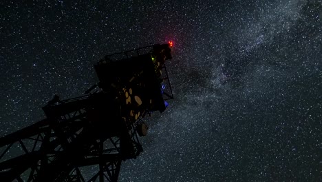 Milky-way-galaxy-circling-over-communication-tower-in-starry-night-sky-Time-lapse-Zoom