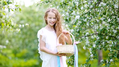 Entzückende-kleine-Mädchen-in-blühender-Apfelgarten-an-schönen-Frühlingstag