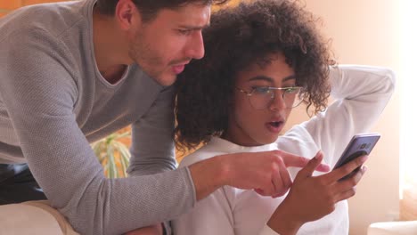 Couple-using-mobile-phone-on-sofa-at-home