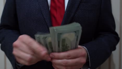 Business-Man-Pulling-Out-Hundred-Dollar-Bills-From-Jacket-Inside-Pocket-and-Counting