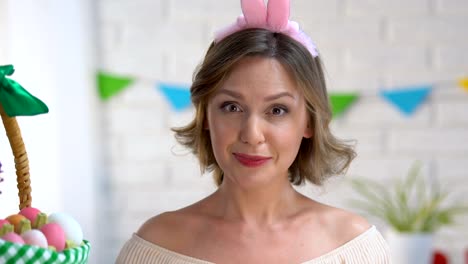 Cheerful-woman-having-fun-holding-brightly-colored-Easter-eggs-near-eyes,-mood