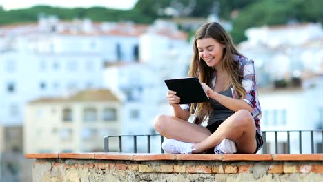 Happy-teen-using-a-tablet-on-vacation