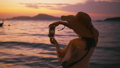 Schöne-Frau,-die-das-Fotografieren-mit-Smartphone-Technologie-am-Paradiesstrand