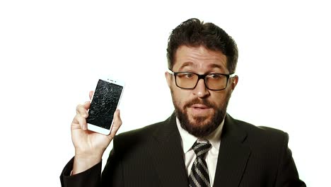 The-concept-of-a-broken-gadget.-Bearded-businessman-in-glasses-showing-broken-smartphone-screen,-he's-in-shock-and-doesn't-know-what-.