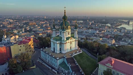 St.-Andrew's-Church,-the-Podil-district-and-Dnieper-River-in-Kiev,-Ukraine.-Aerial-shot.-4K,-UHD