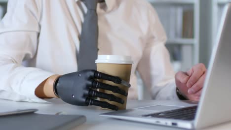 Geschäftsmann-mit-Robotik-Prothesen-Arm-arbeitet-im-Büro