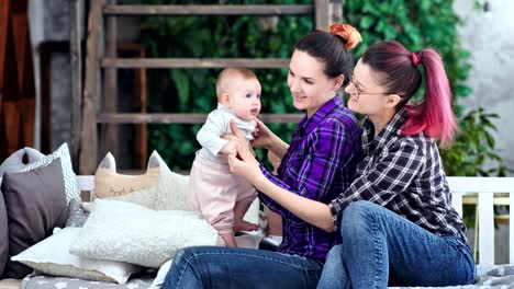 Mujer-joven-madre-sonriendo-y-jugando-con-poco-bebé-lindo-en-el-interior-del-hogar-mediano-tiro-largo