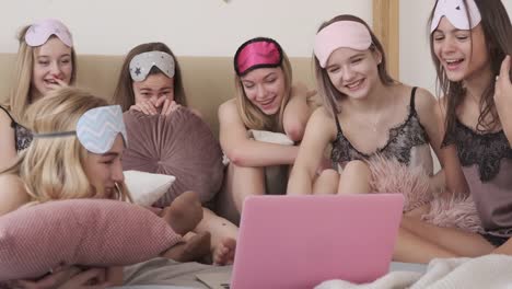 Happy-teen-girls-enjoying-media-content-on-laptop-during-slumber-party