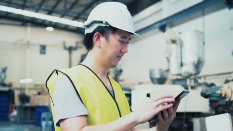 Young-Asian-male-factory-worker-using-a-digital-tablet