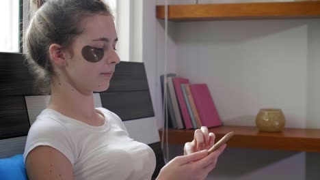 Woman-with-Eye-Patches-Using-Smartphone