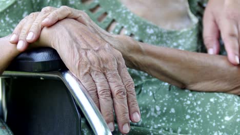 Hija-cuidar-madre-anciana-en-silla-de-ruedas-en-casa