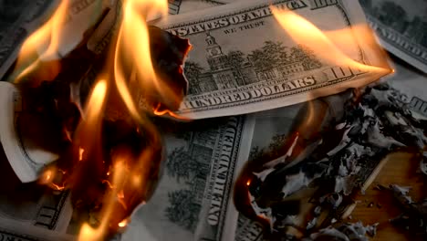 heap-of-paper-money-us-dollar-flaming-on-a-table