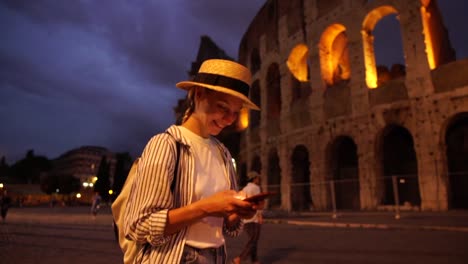 Sonriente-mujer-joven-caucásica-disfrutando-de-caminar-en-Roma-utilizando-la-aplicación-en-el-teléfono-inteligente-para-buscar-rutas-en-línea-a-través-de-una-buena-conexión-a-Internet-4G-en-itinerancia