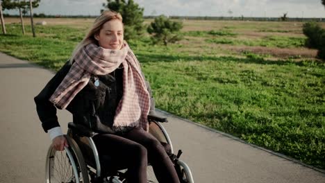 Smiling-handicapped-woman-in-wheelchair-on-enjoyable-outdoor-walk