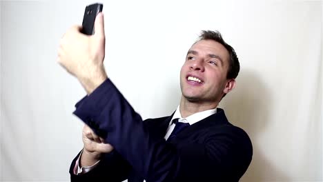 Young-handsome-businessman-making-selfie,-smiling-and-waving-his-hand.