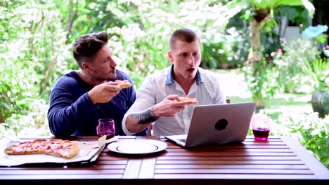 Gay-couple-having-pizza-for-lunch.-Convincing-talk.