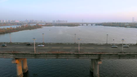 Luftbild-Autoverkehr-auf-Flussbrücke-am-Abend