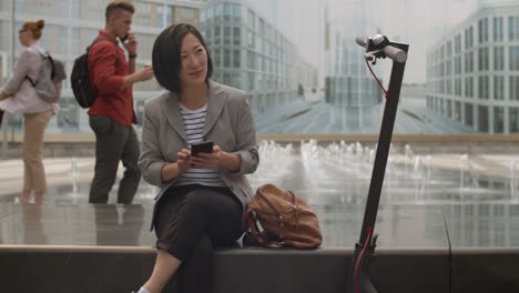 Mujer-asiática-usando-Smartphone-al-aire-libre