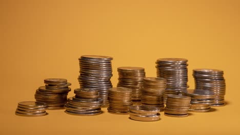 Rows-of-money-coins-on-gold-background