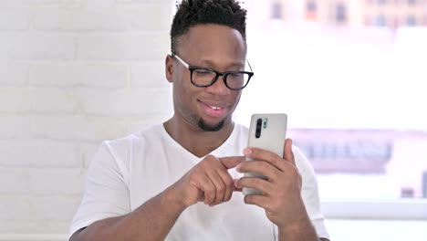 The-Portrait-of-Relaxed-Casual-African-Man-using-Smartphone