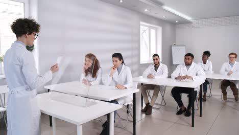 Teacher-in-Lab-Coat-Giving-Lecture-with-Futuristic-Interactive-AR-Touchscreen