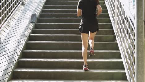 Hermosa-adolescente-asiática-atleta-corriendo-en-un-paso-elevado-en-la-puesta-de-sol-de-la-ciudad.