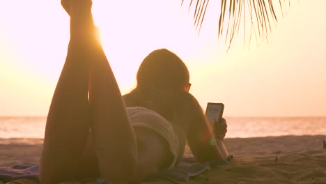 CLOSE-UP:-Tourist-Mädchen-genießt-Sommerabend-am-Strand-durch-Fummeln-mit-ihrem-Handy