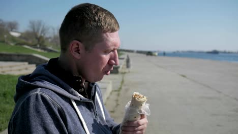 Portrait-of-man-in-a-wheelchair-close-up-eats-shawarma,-lonesome-disabled-man