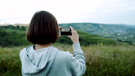 Frau-nimmt-eine-schöne-Landschaft-auf-Kamera-Handys.