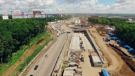 huge-traffic-roundabout-under-construction-and-long-road,-aerial-shot,-drone-is-flying-along