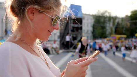 junge-Frau-in-Gläser-mit-Smartphone-in-Händen-bei-Street-in-der-Innenstadt-von