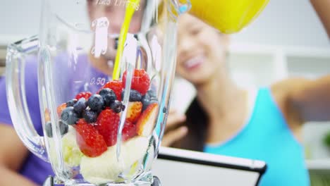 Ethnic-male-female-using-kitchen-blender-fresh-juice