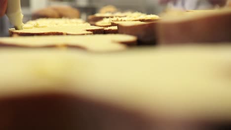 manos-de-chef-de-pastelería-rellenos-de-tortas-de-pan-dulce-de-Pascua-con-crema-pastelera,-closeup-en-la-encimera-en-confitería