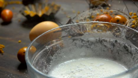 Sugar-powder-is-poured-into-a-bowl-to-prepare-a-glaze-for-Easter-baking